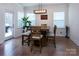 Cozy dining area with modern lighting, hardwood floors, and a view of the backyard at 938 Moose Trl, Matthews, NC 28104