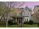 Charming two-story home features a welcoming porch, a well-manicured lawn, and beautiful landscaping at 9832 Sunriver Rd, Huntersville, NC 28078