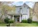 Charming two-story home features a welcoming porch, a well-manicured lawn, and beautiful landscaping at 9832 Sunriver Rd, Huntersville, NC 28078