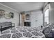 View of bedroom with neutral walls and carpet, showing bench, closet, doorway and decorative painting at 10728 Bere Island Dr, Charlotte, NC 28278