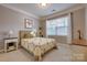 Comfortable bedroom featuring carpeted floors, large window, and quilt covered bed, great for relaxation at 10728 Bere Island Dr, Charlotte, NC 28278