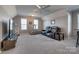 Large bonus room featuring a ceiling fan, large TV, and reclining sofa, perfect for relaxation and entertainment at 10728 Bere Island Dr, Charlotte, NC 28278