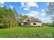 Large backyard with mature trees and a view of the screened in porch on the side of this beautiful home at 109 Redbird Ln, Weddington, NC 28104