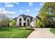 Stunning two-story home with a manicured lawn, circular driveway and a light colored brick exterior at 109 Redbird Ln, Weddington, NC 28104