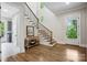 Elegant foyer features a staircase with hardwood treads, natural light, and a stylish accent table at 109 Redbird Ln, Weddington, NC 28104