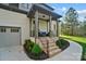 Charming front porch with comfortable seating, decorative plants, and brick steps, creating a welcoming entrance at 109 Redbird Ln, Weddington, NC 28104