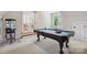 Game room with a pool table, popcorn machine, and hardwood floors leading to an open area, offering entertainment at 109 Redbird Ln, Weddington, NC 28104