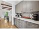 Contemporary kitchen with gray cabinets, stainless wine fridge, and open access to dining area at 109 Redbird Ln, Weddington, NC 28104