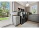 Well-equipped laundry room features modern gray cabinetry, stainless steel appliances, and natural light at 109 Redbird Ln, Weddington, NC 28104