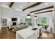 Open concept living room and kitchen with wood beams, fireplace and recessed lights at 109 Redbird Ln, Weddington, NC 28104