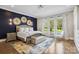 Inviting main bedroom with decorative wall, large windows, hardwood floors, and comfortable furnishings at 109 Redbird Ln, Weddington, NC 28104