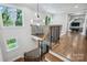 Elegant staircase with hardwood treads, iron railings, and abundant natural light from large windows at 109 Redbird Ln, Weddington, NC 28104