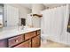 Bathroom with a white sink, wood cabinets, a toilet, a shower, and a framed mirror at 11222 Huntington Meadow Ln, Charlotte, NC 28273