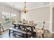 Cozy dining area featuring a rustic wooden table with stylish chairs, a bench, and a chandelier at 11222 Huntington Meadow Ln, Charlotte, NC 28273