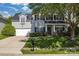 Traditional two-story house with a well-kept lawn, complemented by black shutters and a tree providing shade at 11222 Huntington Meadow Ln, Charlotte, NC 28273