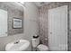 Charming half bathroom featuring floral wallpaper and a pedestal sink at 11415 Serenity Way, Charlotte, NC 28269