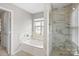 This bathroom features a soaking tub with modern fixtures and a tiled glass shower at 11415 Serenity Way, Charlotte, NC 28269