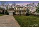 Charming two-story home with a welcoming front porch and well-maintained lawn at dusk at 11415 Serenity Way, Charlotte, NC 28269