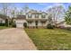 Charming two-story home with a welcoming front porch and well-maintained lawn and long concrete driveway at 11415 Serenity Way, Charlotte, NC 28269