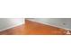 An empty room shows the warm hardwood flooring and base molding at 11415 Serenity Way, Charlotte, NC 28269