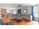 Open-concept living room with hardwood floors, a ceiling fan, and view into the kitchen at 11415 Serenity Way, Charlotte, NC 28269