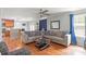 Open-concept living room with hardwood floors, a ceiling fan, and view into the kitchen at 11415 Serenity Way, Charlotte, NC 28269