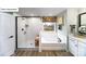 A modern bathroom features a stand-up shower, soaking tub, and decorative light fixture above the vanity at 118 Fordingbridge Ln, Mooresville, NC 28115