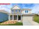 Charming two-story home with brick and siding, features a manicured lawn, and an attached two-car garage at 118 Fordingbridge Ln, Mooresville, NC 28115