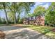 Brick home with lush greenery and a long driveway at 119 Lakenheath Ln, Matthews, NC 28105