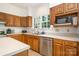 Well-lit kitchen with stainless steel appliances, light countertops, and oak cabinets at 119 Lakenheath Ln, Matthews, NC 28105