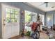 Enclosed sunroom needing tidying with brick floor, multiple windows, and natural light at 119 Lakenheath Ln, Matthews, NC 28105
