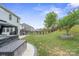 Expansive backyard with a manicured lawn, hardscape patio, and black metal fence at 121 Little Kennerly Dr, Mooresville, NC 28115