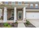 Inviting front porch with white columns, a cozy seating area, and lush landscaping at 121 Little Kennerly Dr, Mooresville, NC 28115