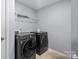 Laundry room with modern, front-load washer and dryer, plus a storage shelf at 121 Little Kennerly Dr, Mooresville, NC 28115