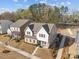 An aerial view of a two story house with white accents, manicured lawn, and tree lined street in a quiet neighborhood at 12110 Anne Blount Aly, Huntersville, NC 28078