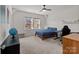 Well-lit bedroom features neutral carpeting, a ceiling fan, a bed, and a desk at 12110 Anne Blount Aly, Huntersville, NC 28078
