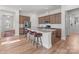 Open kitchen with center island with seating, stainless appliances, hardwood floors, and pendant lights with a view to entry at 12110 Anne Blount Aly, Huntersville, NC 28078