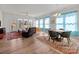 Open-concept living room with hardwood floors, a ceiling fan, comfortable seating, and large windows with natural light at 12110 Anne Blount Aly, Huntersville, NC 28078