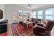 Bright living room featuring hardwood floors, leather furniture, blue curtains, and large windows with backyard views at 12110 Anne Blount Aly, Huntersville, NC 28078