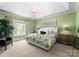 Bright bedroom with green walls, floral bedding, and ample natural light from the window at 12627 Ninebark Trl, Charlotte, NC 28278
