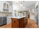 Bright kitchen with an island, white cabinets, stainless steel appliances, and open floor plan at 12627 Ninebark Trl, Charlotte, NC 28278