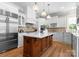 Bright kitchen with an island, white cabinets, stainless appliances, and pendant lighting at 12627 Ninebark Trl, Charlotte, NC 28278