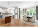 Kitchen with island, white cabinets, stainless appliances and connected dining room at 12627 Ninebark Trl, Charlotte, NC 28278