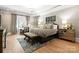Luxurious main bedroom with a large bed, seating area, and natural light at 12627 Ninebark Trl, Charlotte, NC 28278