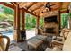 Inviting outdoor space featuring a stone fireplace, wooden beams, and lush greenery views at 12627 Ninebark Trl, Charlotte, NC 28278