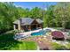 Aerial view of an outdoor oasis featuring a pool, hot tub, and covered patio area at 12627 Ninebark Trl, Charlotte, NC 28278