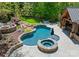 Serene backyard featuring a uniquely designed swimming pool, hot tub, and poolside pavilion at 12627 Ninebark Trl, Charlotte, NC 28278