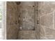 Walk-in shower featuring stone walls, built-in bench and shelving, and dual shower heads at 12627 Ninebark Trl, Charlotte, NC 28278