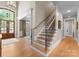 Beautiful staircase with hardwood steps and iron railings in a bright, open entryway at 12627 Ninebark Trl, Charlotte, NC 28278
