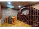 Custom wine cellar with brick walls, a wood barrel table, and ample bottle storage at 12627 Ninebark Trl, Charlotte, NC 28278